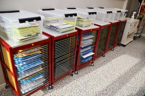 Ein weiterer EInblick in den Kunstraum mit Tuschkästen und einem Regal mit verschiedenen Ebenen auf denen die Bilder trocknen können.