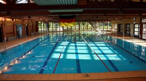 Das Schwimmbecken des Hallenbads über dem eine Deutschlandflagge hängt