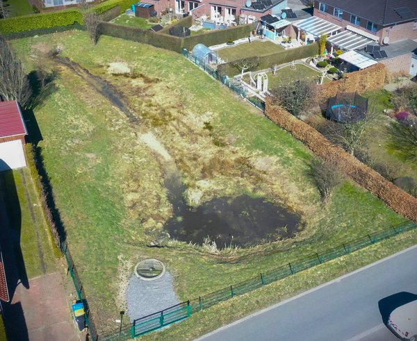 Das kleinere Becken liegt an einer Straße und Wohnhäusern an.