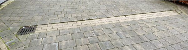 Gepflasterte Rinne mit Ablauf