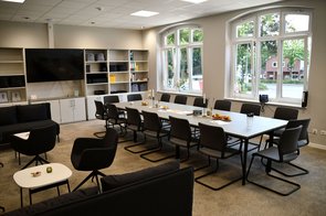 Das helle große Lehrerzimmer mit einem großen Bildschirm an der Wand strahlt Ruhe und Professionalität aus.