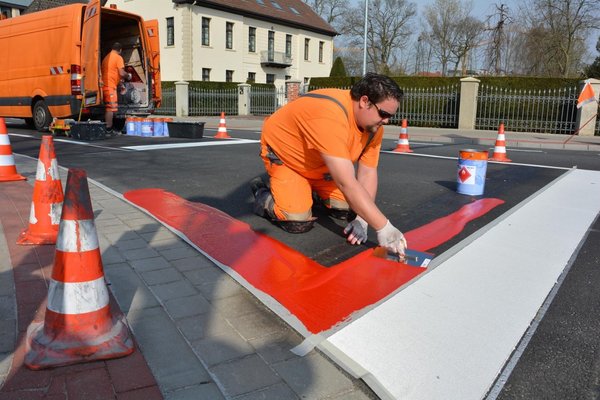 Ein Arbeiter markiert die Flächen rot.